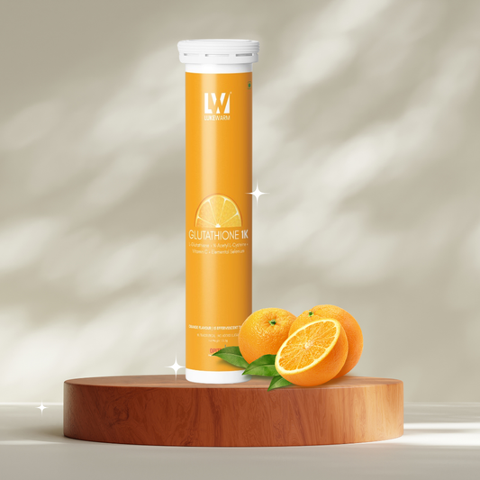 A tall orange cylindrical bottle labeled 'BLAZETHONE INK' stands on a round wooden pedestal with whole and sliced oranges and green leaves beside it against a softly lit beige background.