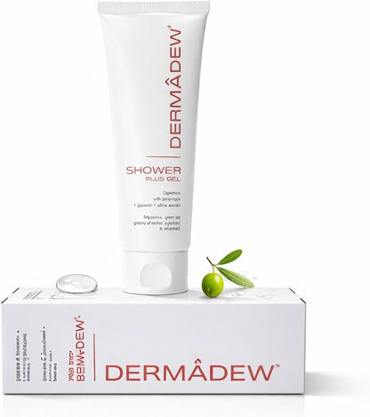 Dermàdew Shower Plus Gel in a white squeeze tube, displayed on top of its white retail box with a small clear gel droplet and a green olive branch prop, against a clean white background.